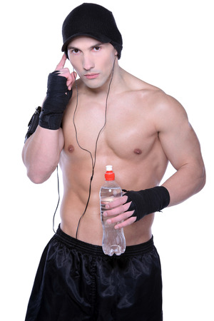 Muscular man with bottle of the water, isolated on white backgroundの写真素材