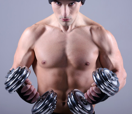Closeup of a muscular young man lifting weightsの写真素材