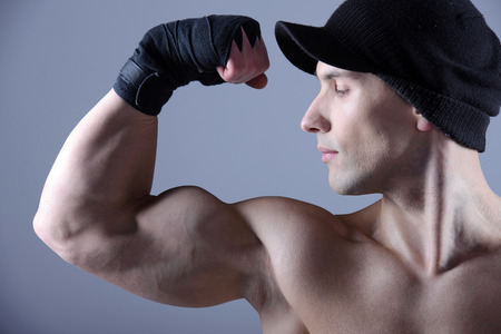 Muscular man flexing his biceps - studio shotの写真素材