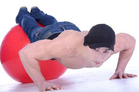 Topless male model performs pushup on floor.の写真素材