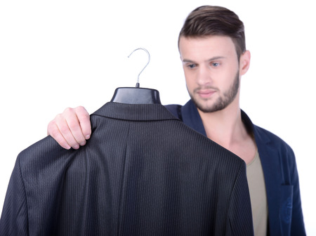 Young man choosing suit jacket during apparel shopping at clothing store isolated on whiteの写真素材