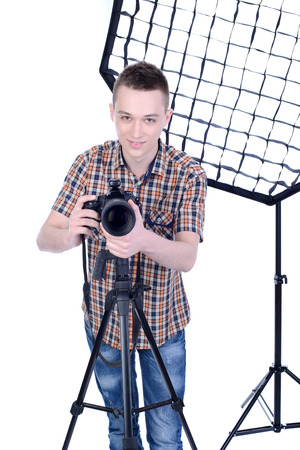 Portrait of young male photographer with professional digital cameraの写真素材