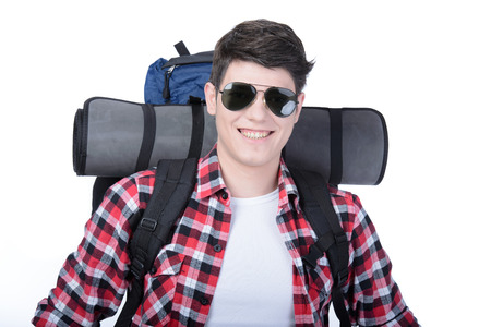 Young man with backpack walking isolated on white backgroundの写真素材