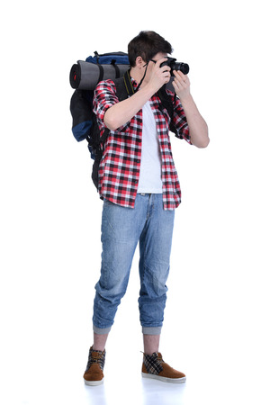 Young man with backpack taking picture isolated on white backgroundの写真素材