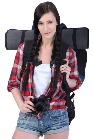 Smiling traveling girl holding a camera and looking at you, closeup portrait. Isolated on white backgroundの写真素材