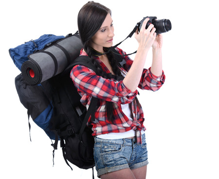 Smiling traveling girl holding a camera and looking at you, closeup portrait. Isolated on white backgroundの写真素材
