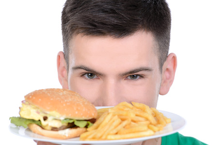 Young man eating fast food isolated on white backgroundの写真素材