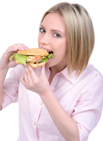 Young woman eating fast food isolated on white backgroundの写真素材