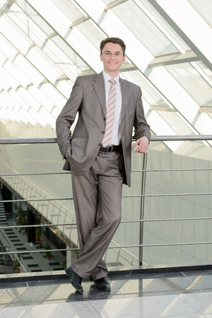 Portrait of a smiling handsome businessman in a business centerの写真素材