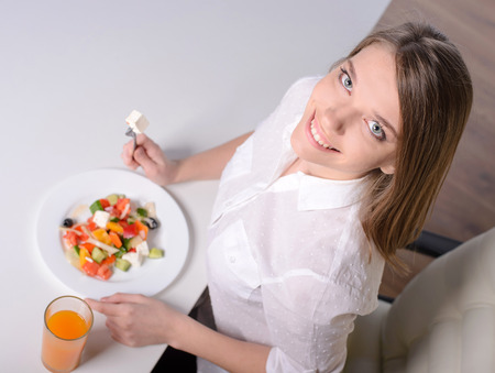 Young beautiful business woman eating salad. View from aboveの写真素材