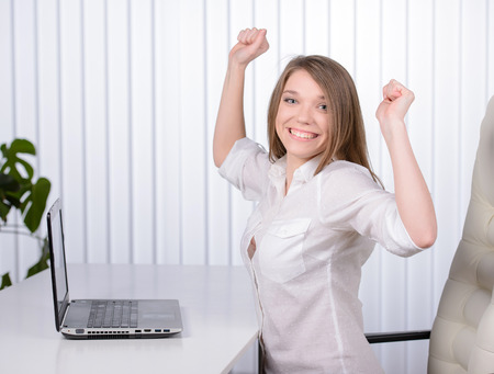 Working in an office. Young pretty business woman with notebook in the officeの写真素材