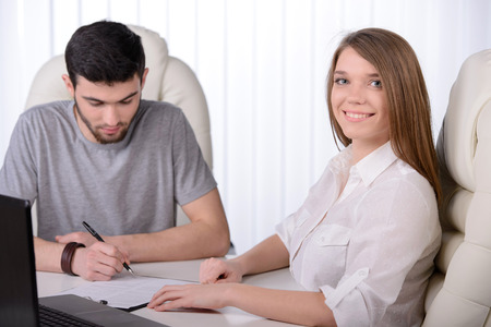 Business man and business woman working in the office. handing the keys and signing a contract.の写真素材