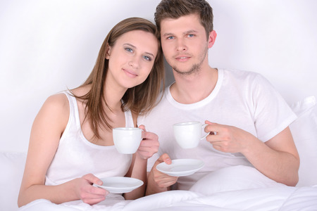 An attractive young couple have breakfast in bedの写真素材