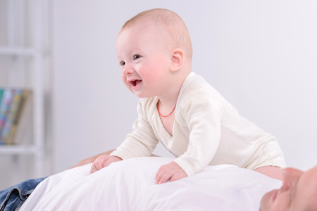 Young Caucasian father playing with baby son at home