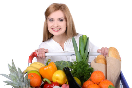 Portrait of a woman holding a shopping basket and shopping cart isolated on white backgroundの写真素材