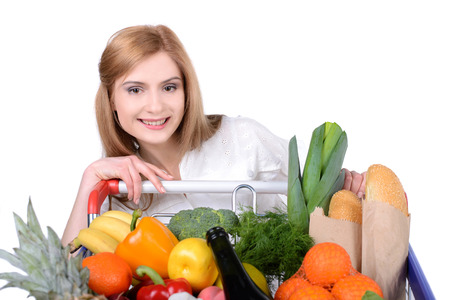 Portrait of a woman holding a shopping basket and shopping cart isolated on white backgroundの写真素材
