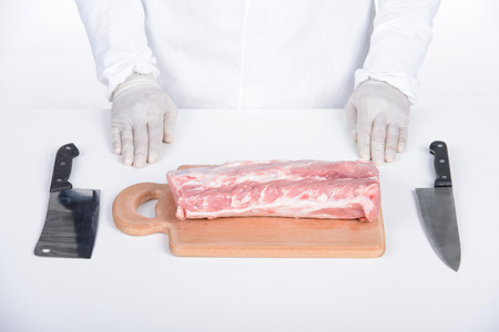 Butcher cutting meat on chopping board, professional cook holding knife and cutting meatの写真素材