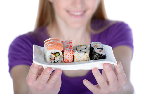 Beauty with sushi. Beautiful woman holding a plate of sushi while standing isolated on whiteの写真素材