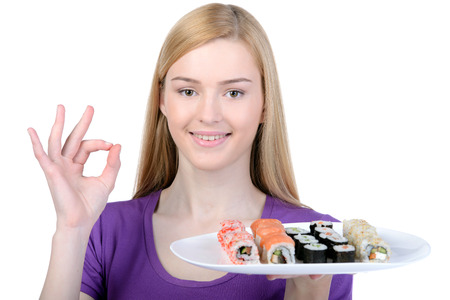 Beauty with sushi. Beautiful woman holding a plate of sushi while standing isolated on whiteの写真素材