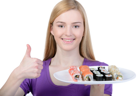 Beauty with sushi. Beautiful woman holding a plate of sushi while standing isolated on whiteの写真素材