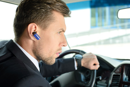 Young successful businessman riding in the carの写真素材