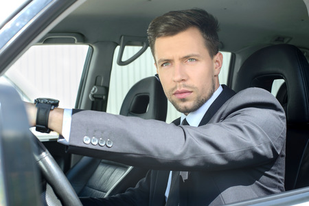 Young successful businessman riding in the carの写真素材