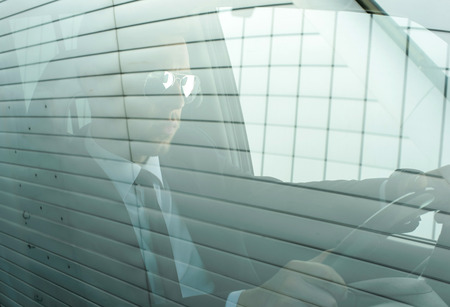 Young successful businessman riding in the carの写真素材