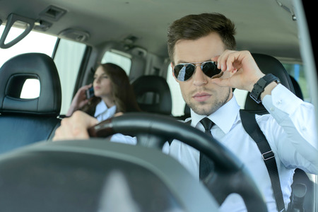 Businessman and business woman traveling in the carの写真素材