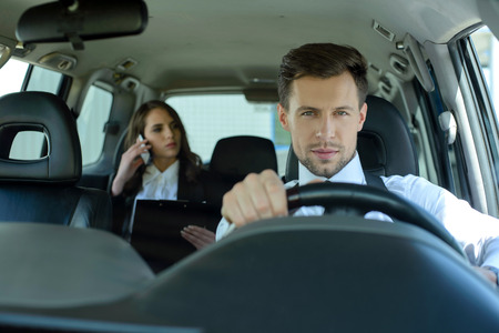 Businessman and business woman traveling in the carの写真素材