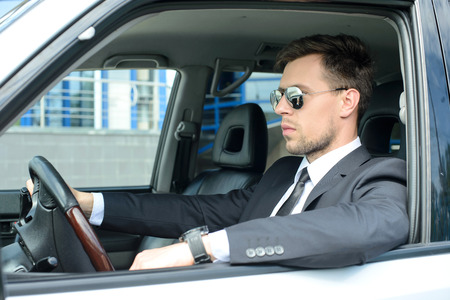 Young successful businessman riding in the carの写真素材