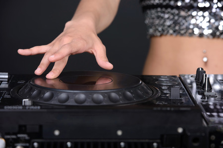 Young sexy dj woman against black background.の写真素材