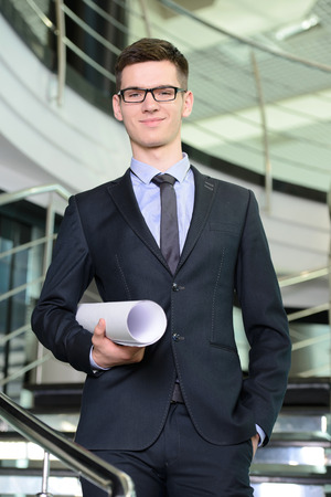 Portrait of a smiling handsome businessman in a business centerの写真素材