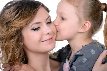 Portrait of happy daughter and her mother, isolated over whiteの写真素材