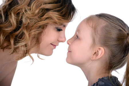 Portrait of happy daughter and her mother, isolated over whiteの写真素材