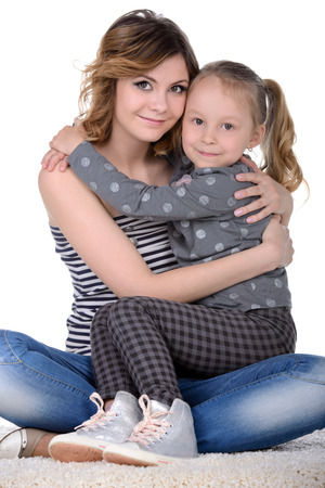Portrait of happy daughter and her mother, isolated over whiteの写真素材