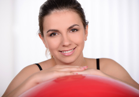 Woman with exercise ball. Beautiful woman leaning at fitness ball and smilingの写真素材