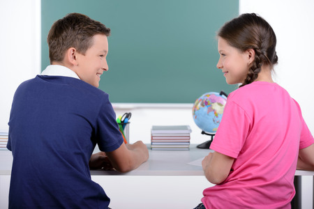 Studying together. Rear view of two little classmates reading a book togetherの写真素材