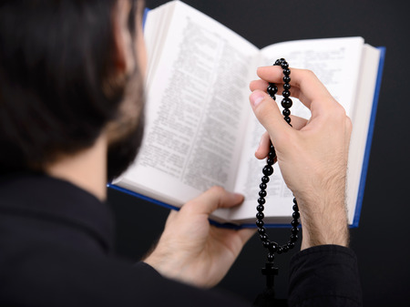 Priest with Holy Bible. Portrait of priest reading the Holy Bible