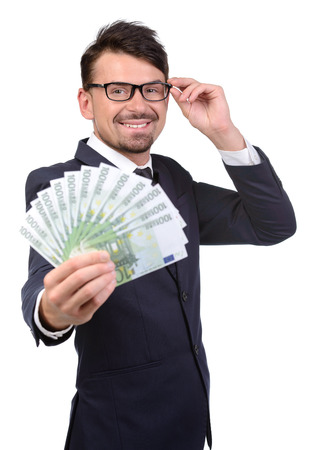 Successful buinessman. Happy young man in formalwear holding money while standing isolated on whiteの写真素材