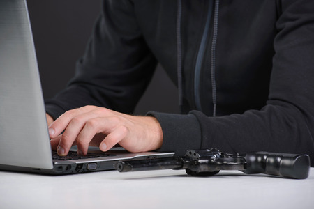 Computer hacking. Close-up of frustrated criminal using computerの写真素材