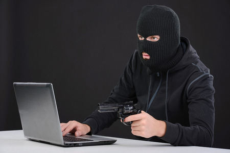 Computer hacking. Close-up of frustrated criminal using computerの写真素材