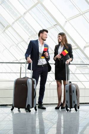 Businessman and business woman communicating to the flight at airportの写真素材