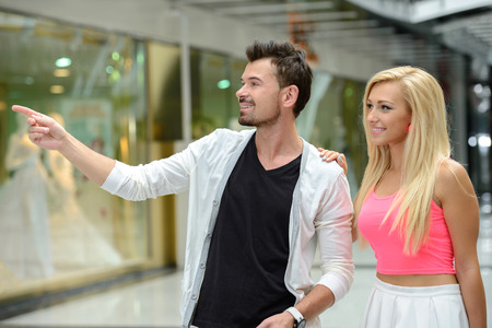 Young beautiful couple with bags for shopping, in shopping centerの写真素材