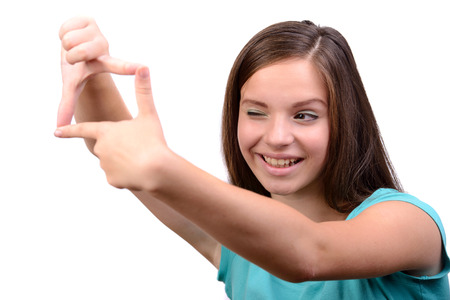 Smiling teenage girl pictures of virtual camera, isolated white backgroundの写真素材