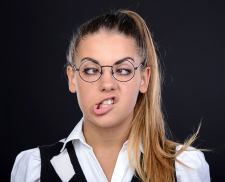 Young nerd woman crazy expression in glasses on black backgroundの写真素材