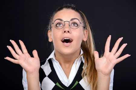 Young nerd woman crazy expression in glasses on black background