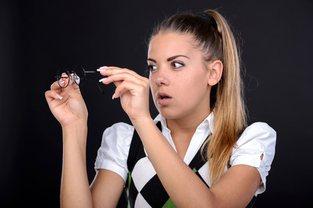 Young nerd woman crazy expression in glasses on black background