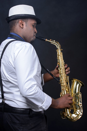 Saxophonist black men in white shirt. Smoke backgroundの写真素材