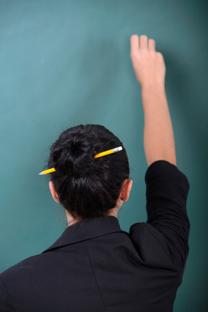 Young smiling student or teacher at the blackboardの写真素材