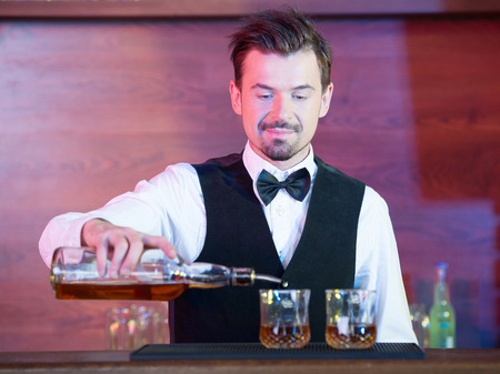 Bartender is making cocktail at bar counterの写真素材